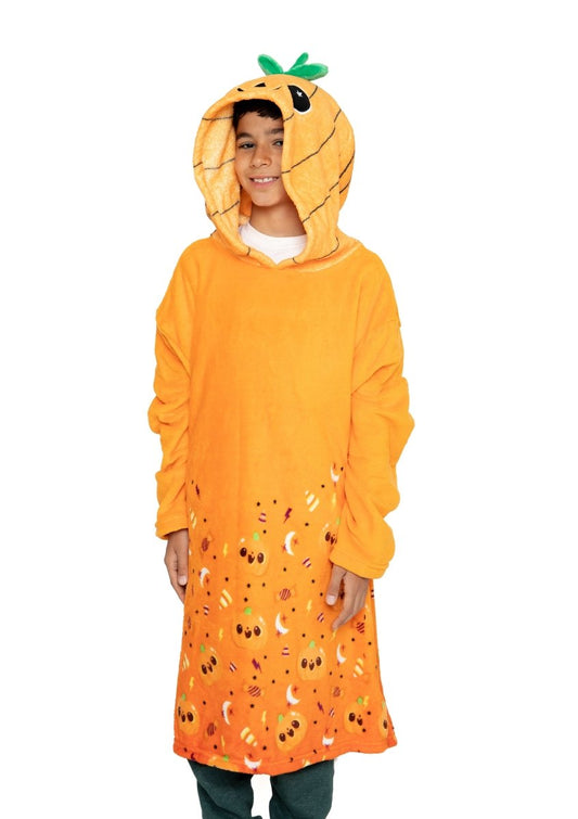 A smiling child wears the Vincent the Pumpkin Hooded Blanket, featuring an oversized orange fleece with a hood shaped like a pumpkin stem and leaf, textured details, and adorable fruit faces on the cozy lower part.