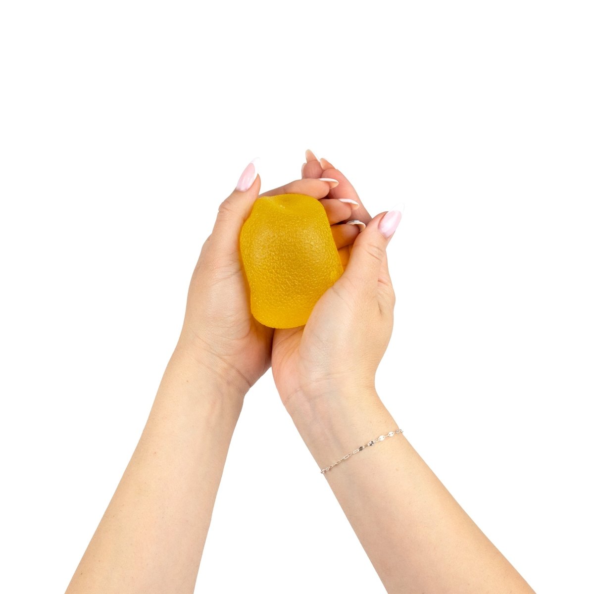 A pair of hands gently squeezes Bubblegum's Favorite Toy - Sugah-mals Gumdrops, a yellow, textured, lemon-shaped sensory stress relief toy, against a white background.