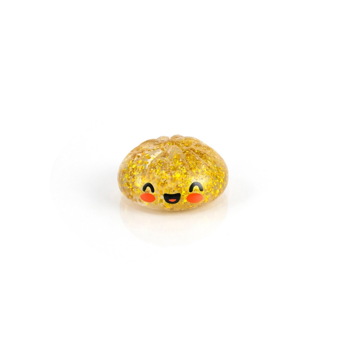 Bubblegum's Favorite Toy - Mystery Dumpling is a small, round, yellow glittery pumpkin-like squishy with a smiling face and red cheeks, shown on a white background.