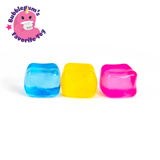 Three colorful Solid Sugah-mals Cubes—blue, yellow, and pink—from "Bubblegum’s Favorite Toy" are lined up on a white background. Above them is a pink unicorn mascot and the toy’s name in bold text.