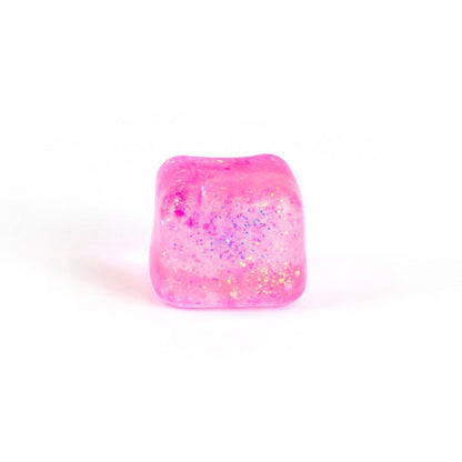 A single pink, translucent Bubblegum's Favorite Toy - Glitter Sugah-mals Cube with embedded colorful glitter is shown against a plain white background.