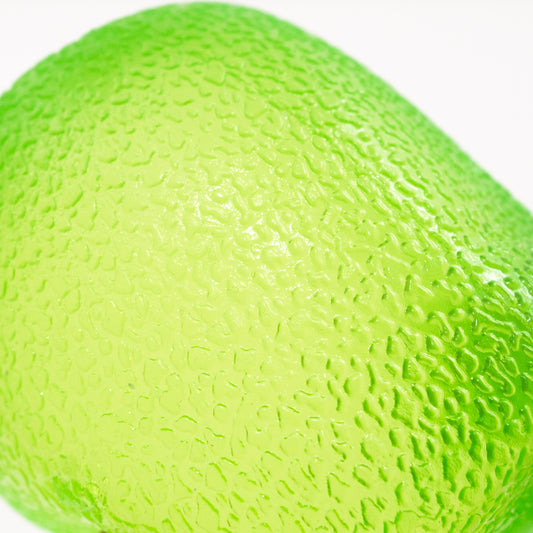 Close-up of Bubblegum's Favorite Toy - Sugah-mals Gumdrops shows the toy's bright green, bumpy surface against a white background, resembling a squishy cube or stress relief toy and filling the frame with its vibrant texture.