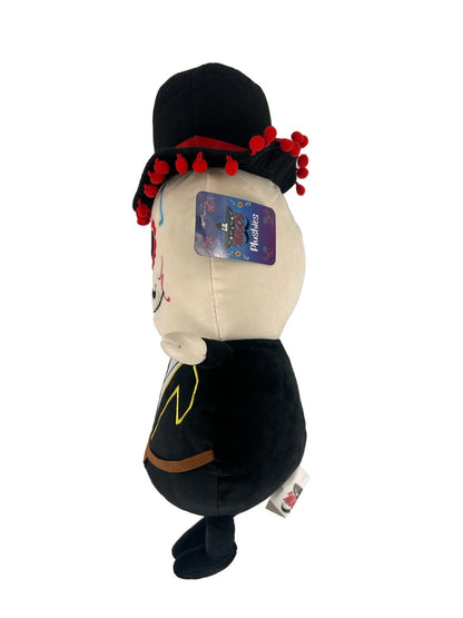 The Lil 'Migos Day of the Dead Plush features a painted face, black outfit, red beaded hat, and attached tag. It stands upright against a white background—perfect for ultra-soft plushie collectors.