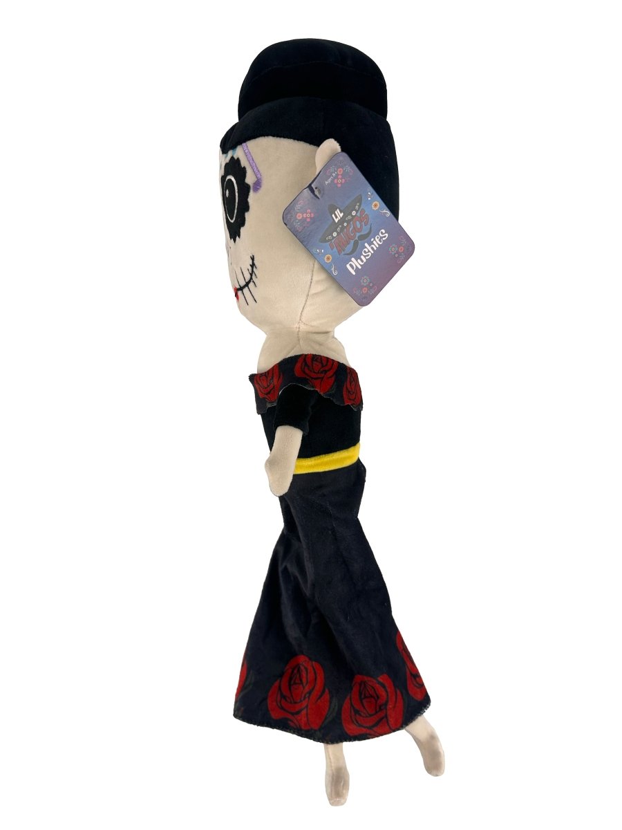The Lil 'Migos Day of the Dead Plush is an ultra-soft doll featuring a skeleton face, black dress with red roses, black hat, and a tag attached to its head.
