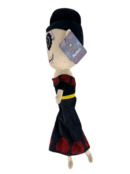 The Lil 'Migos Day of the Dead Plush is an ultra-soft doll featuring a skeleton face, black dress with red roses, black hat, and a tag attached to its head.