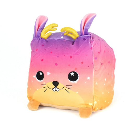 Jinx the Jackalope is a machine washable plush toy with a square body, pink-to-yellow gradient, tiny legs, smiling whiskered face, starry eyes, purple ears, gold antlers, and star patterns—perfect for fans of soft plush toys!.