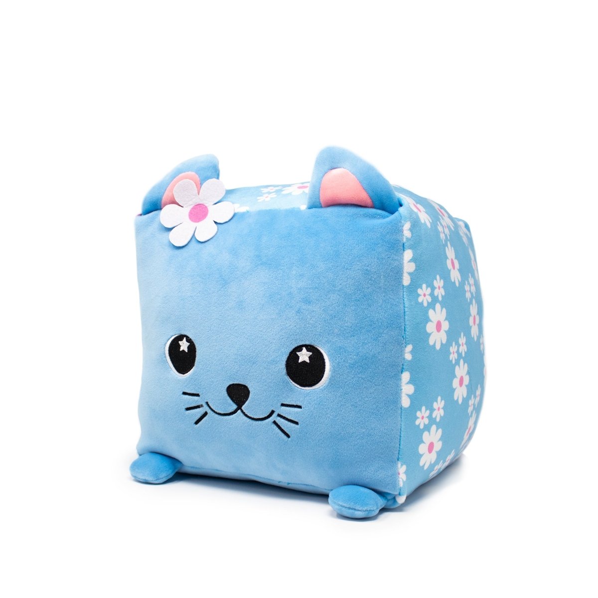 Maisie the Cat Plushie is a cube-shaped soft toy with a blue exterior, cute cat face, ears, and flower design. It features embroidered eyes, nose, and whiskers along with a white and pink flower on one ear.