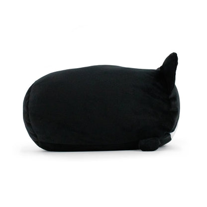 A plush toy, Moosh-Moosh's Midnight the Cat Plushie, is shown in a side view. The toy is curled up as if sleeping, with a round body, a small tail tucked under, and pointed ears. The surface appears soft and velvety. This soft and squishy animal pillow rests against a plain white background.