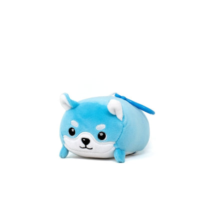 A cute plush toy resembling a small, round blue dog is actually Yuki the Snow Fox Clip-On. It features white facial accents, small pointed ears, and an adorable expression, showcased on a plain white background.