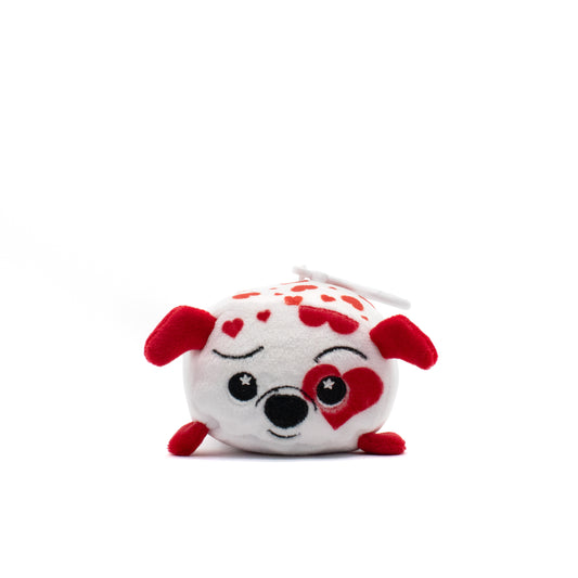 Ed the Dalmatian Plush Clip-On is a cute, square-shaped stuffed animal with red ears, one open eye, and a red heart covering the other. Predominantly white with scattered red hearts, it makes for an adorable cuddle buddy.