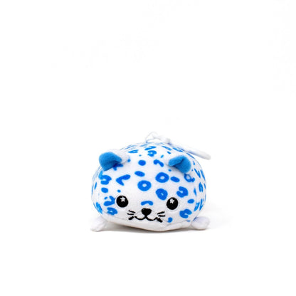 Snowie the Snow Leopard Clip-On is a round, plush keychain toy with blue spots, small blue ears, black eyes, and a little smile—perfect as a cute holiday accessory.