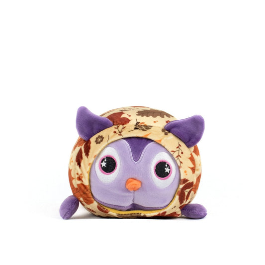 The Archie Spooky Slumber Plushie is a round, ultra-soft stuffed owl with big purple eyes, purple ears and feet, and a body featuring a brown and orange autumn leaf pattern, shown on a plain white background.