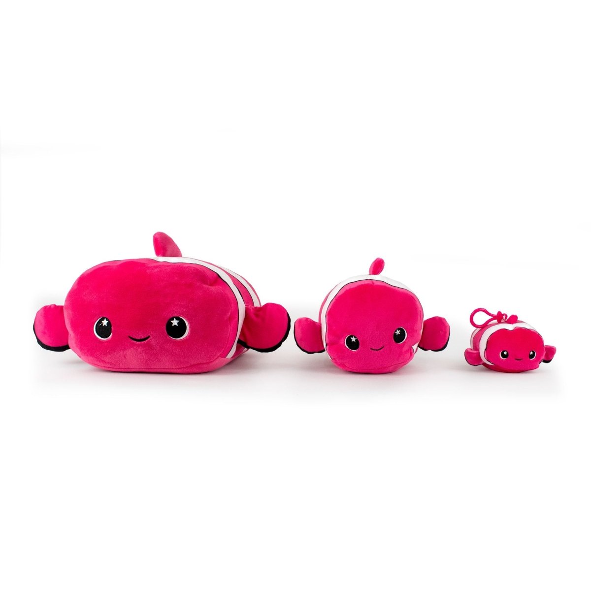 Three Skipper the Clownfish plushies in pink, featuring happy faces and rectangular bodies, are aligned from largest to smallest. Each plush has similar designs with fins and tails.