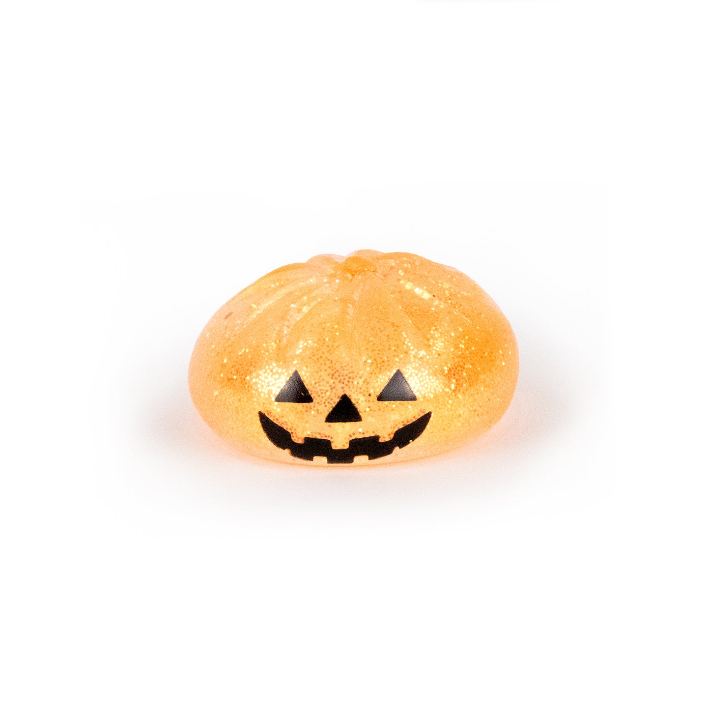 A small, glittery orange Bubblegum’s Favorite Toy - Spooky Mystery Dumpling with a black, smiling jack-o’-lantern face is centered on a white background.
