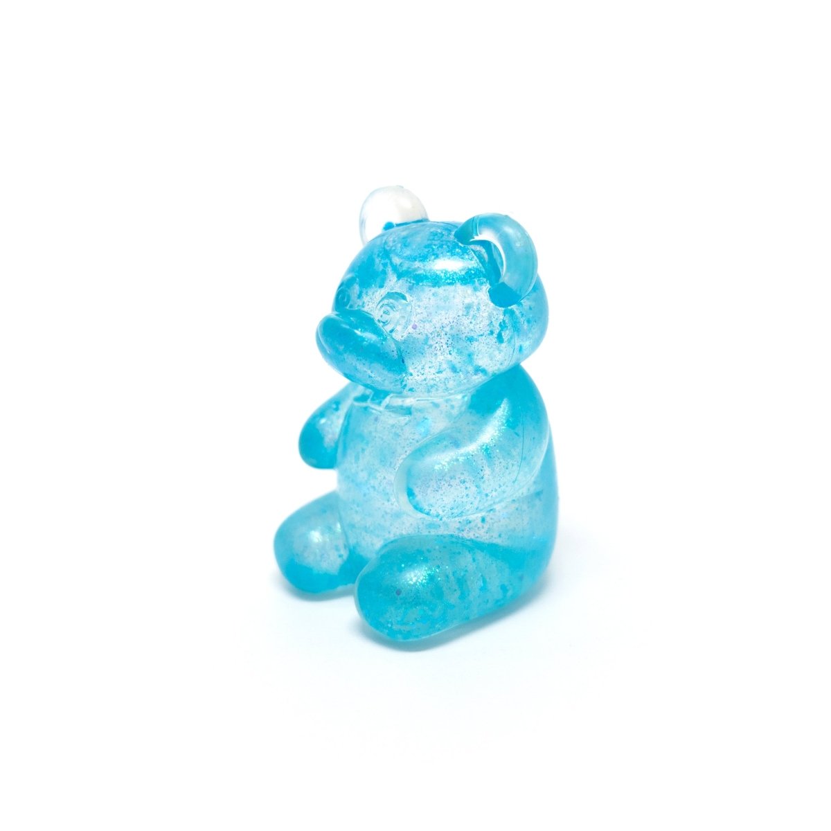 A small, translucent blue gummy bear—Bubblegum’s Favorite Toy - Glitter Maltose Bears—sits upright on a white background, resembling a glitter bear sensory toy that’s perfect for squishy stress relief.