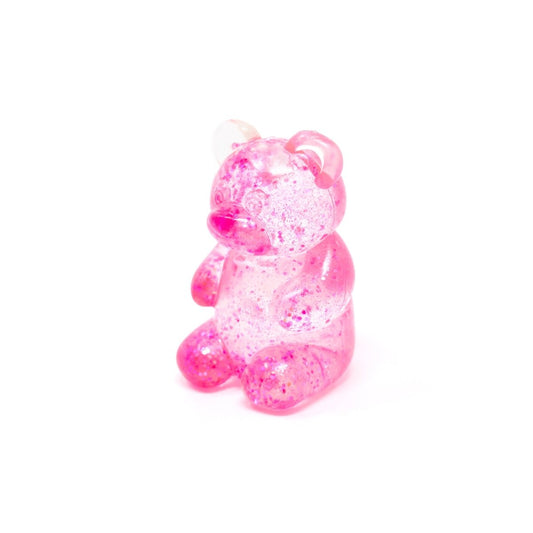 A sparkling, pink, translucent bear-shaped gummy candy from “Bubblegum’s Favorite Toy - Glitter Maltose Bears,” featuring shimmering accents and displayed against a plain white background.