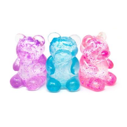Three translucent gummy bear candies—purple, blue, and pink—sit side by side on a white background, each sparkling with glitter in a playful nod to Bubblegum’s Favorite Toy - Glitter Maltose Bears.