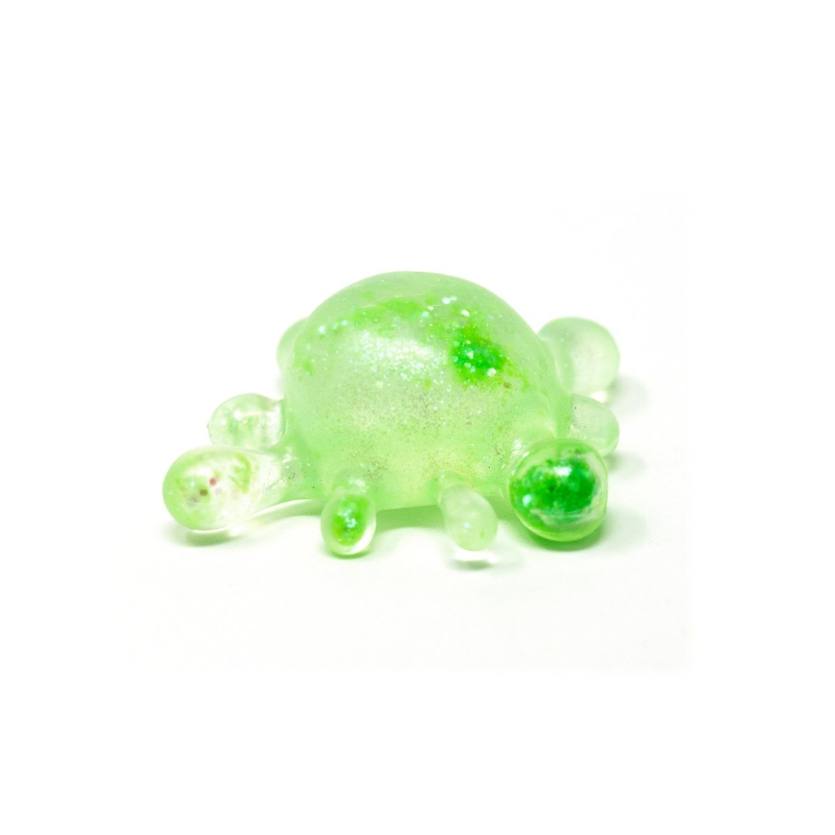 A small, translucent green glass sculpture resembling a turtle with a rounded shell and stubby legs, reminiscent of Bubblegum’s Favorite Toy - Splat Squishy sensory toy, is placed on a plain white background.