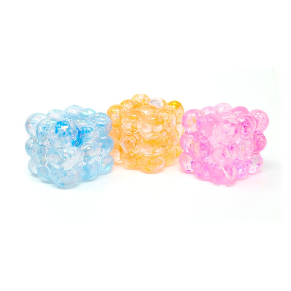 Three translucent Glitter Bubble Cubes from Bubblegum’s Favorite Toy, in blue, yellow, and pink, are arranged side by side on a white background.