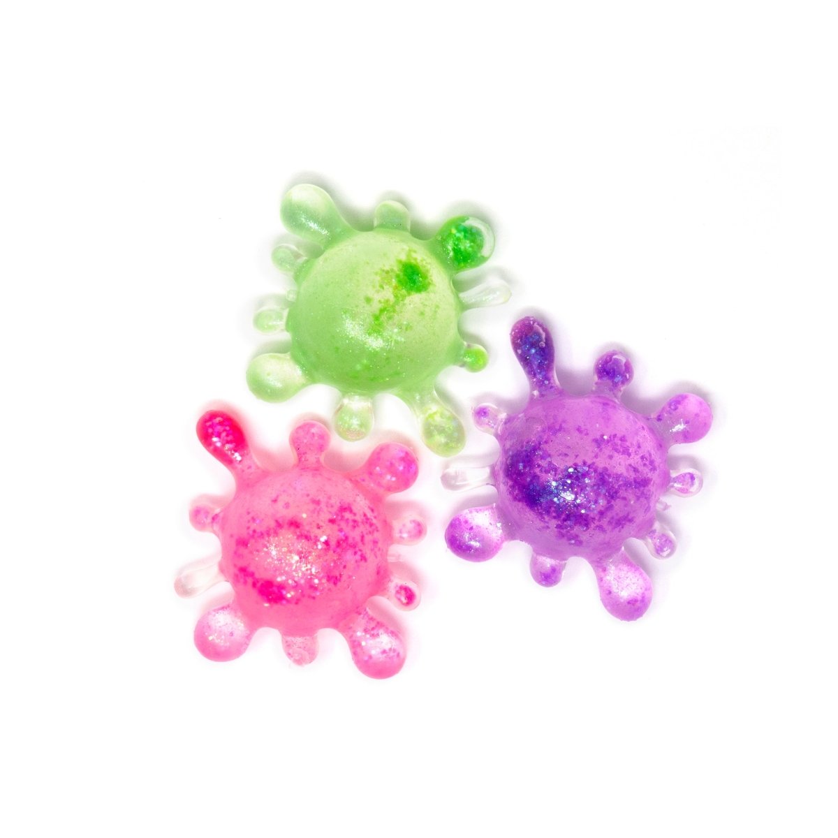 Three colorful, glittery, splat-shaped toys—Bubblegum’s Favorite Toy - Splat Squishy—in green, pink, and purple are arranged on a white background. Perfect as a sensory toy or stress relief squishy, these fun splats add a playful touch to any collection.