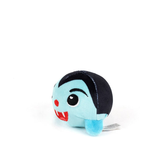 The Vlad Spooky Plushy Skwishy is a small, round blue plush toy featuring black hair, a red nose, pointed fangs, and an embroidered smiling face, resembling a cute vampire character.