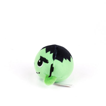 The Frankie Spooky Plushy Skwishy is a round, green plush toy with black hair and stitched details inspired by Frankenstein’s monster, shown at a slight angle on a white background.