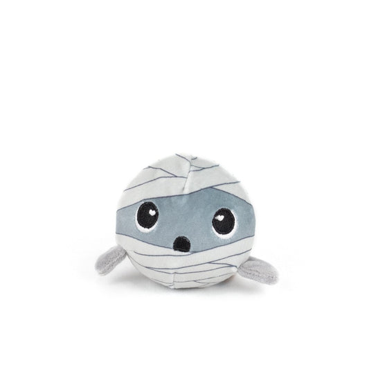 The Nile Spooky Plushy Skwishy is a round plush toy resembling a cute mummy, featuring gray fabric, stitched bandages, wide black and white eyes, and small outstretched arms.