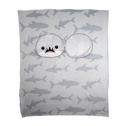 The 2-in-1 Pillow Blanket - Crush the Shark is a gray blanket with shark silhouettes and a sewn-on hood shaped like a cartoon shark head, featuring a wide open mouth and cute eyes.