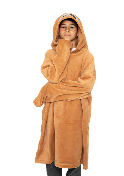 A person stands wearing an oversized Hooded Blanket - Speedy the Sloth with sleeves, their hand resting on their chin against a plain white background.