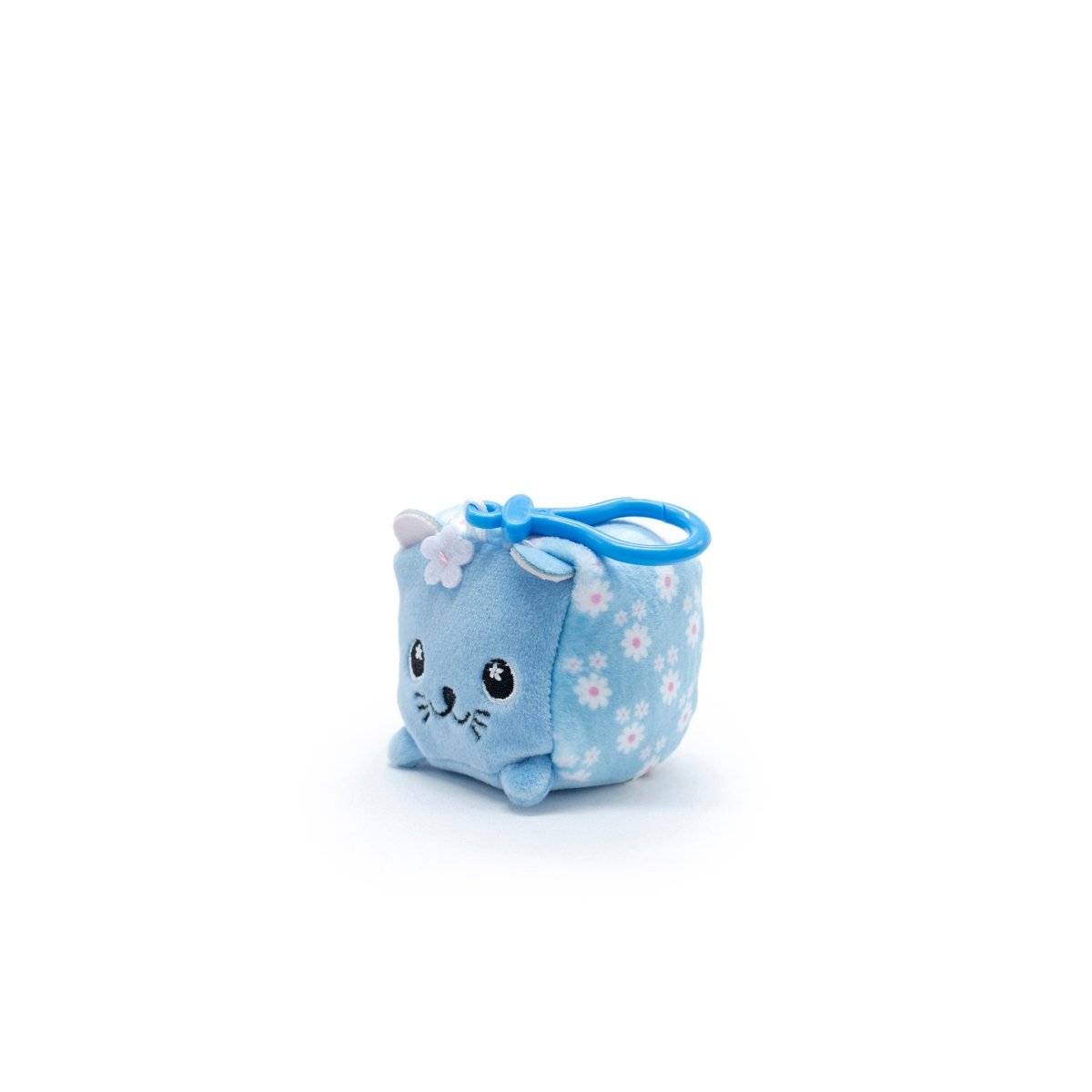 Maisie the Cat Square Plush Clip-On is an adorable cube-shaped toy with blue fabric and floral patterns. It features small ears, embroidered whiskers, a smiling expression, and a handy blue loop on top for easy attachment. Part of the Moosh-Moosh Series 1.