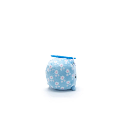 This compact Moosh-Moosh Series 1 plush clip-on is named Maisie the Cat and sports a light blue fabric with pink and white flowers. It has an adorable face with small eyes, a tiny mouth, and a playful light blue fin or wing atop its head, all against a plain white background.