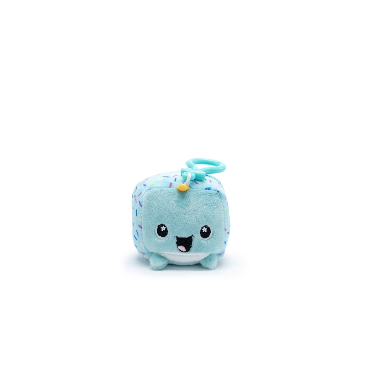 Poindexter the Narwhal from the Moosh-Moosh Series 1 collection is a small, blue cube-shaped plush clip-on toy with a smiling face, tiny limbs, colorful sprinkles, and a yellow horn. The plastic ring allows it to hang as a clip-on against the plain white backdrop.