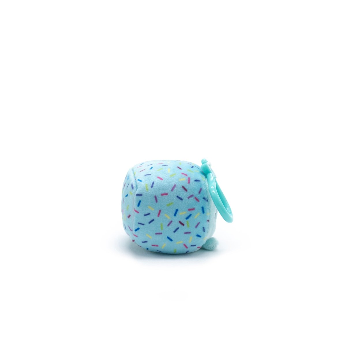 A small, light blue plush cube with a colorful sprinkles pattern and a teal plastic clip resembles Poindexter the Narwhal from the Moosh-Moosh Series 1 collection, set against a plain white background.