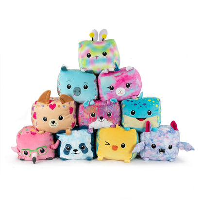 A pyramid of soft, colorful plushie cube toys showcases animal designs including Flora the Bee plushie, unicorn, dog, pig, panda, and dragon. Each toy features unique patterns and expressions for a vibrant and playful display.