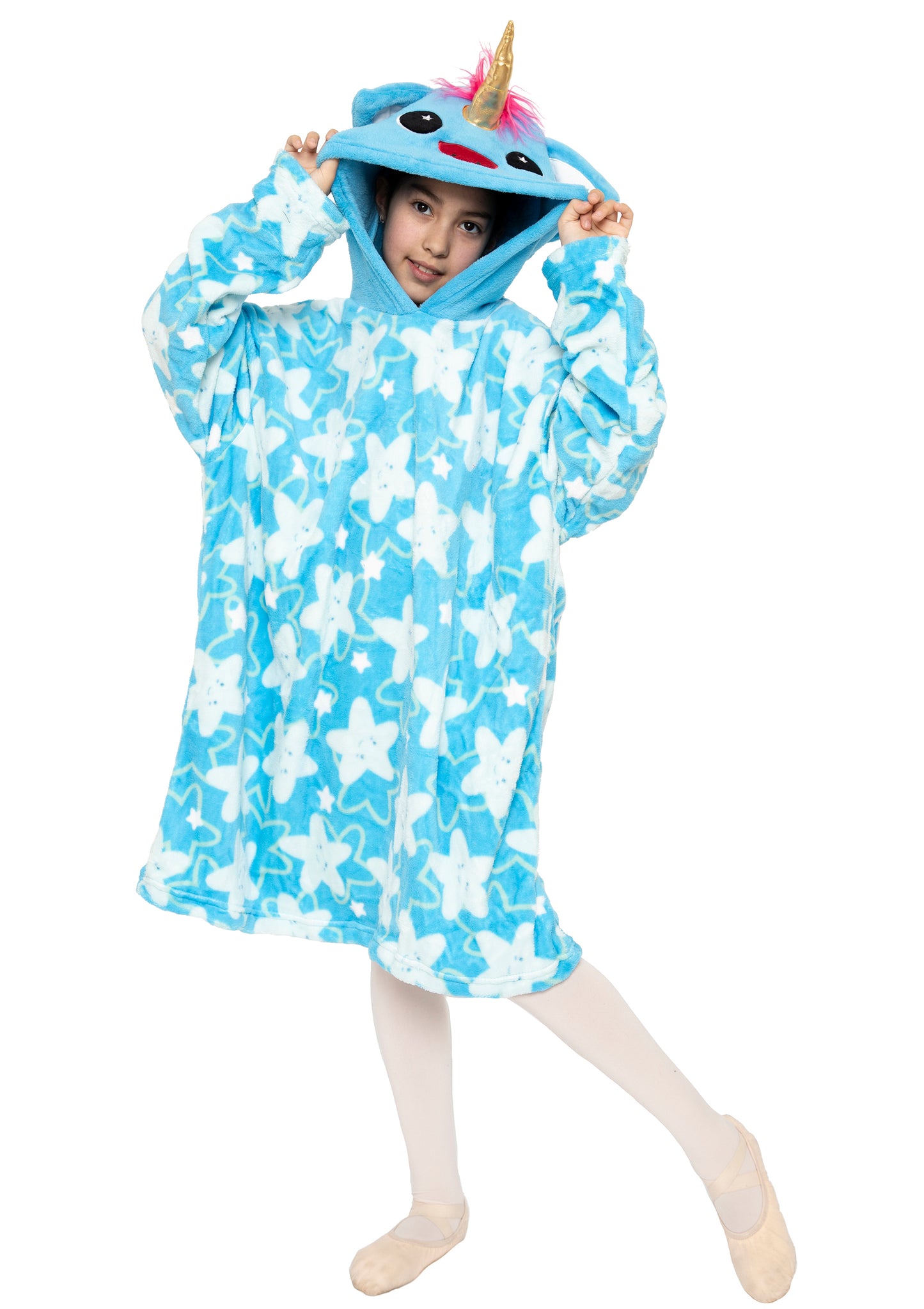 A child playfully poses on one foot, holding the hood of the "Hooded Blanket - Sparkle the Unicorn," which features a blue, star-patterned design with a unicorn horn, ears, and face on the hood.