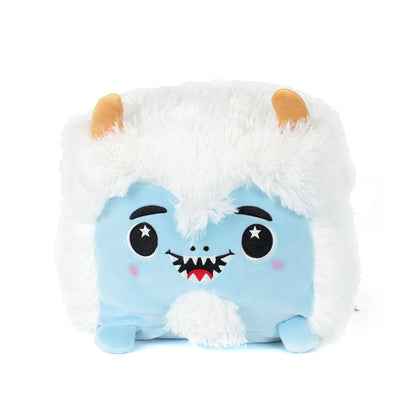 Yara the Yeti is a square, plush toy with a blue face, white fluffy fur, small orange horns, starry embroidered eyes, a smiling mouth with pointed teeth, tiny blue feet—and it's machine washable for easy care.