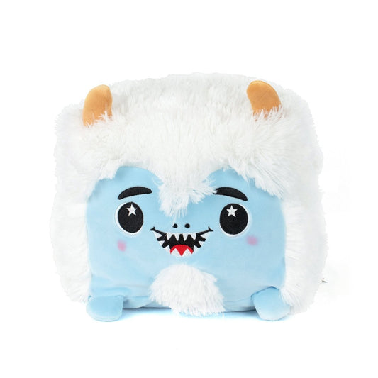 Yara the Yeti is a square, plush toy with a blue face, white fluffy fur, small orange horns, starry embroidered eyes, a smiling mouth with pointed teeth, tiny blue feet—and it's machine washable for easy care.