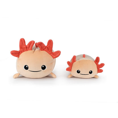 Two Pearl the Axolotl plushies with pink bodies, red feathery head frills, black eyes, and smiles sit side by side on a white background. One is larger than the other.