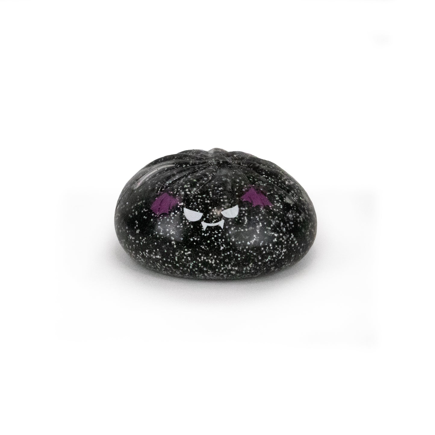 A small, round Spooky Mystery Dumpling from Bubblegum’s Favorite Toy collection, black with speckled details and an adorable angry cartoon face—complete with purple eyebrows and fangs—displayed against a plain white background.