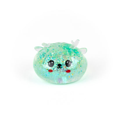 A round, glittery light-green Bubblegum’s Favorite Toy - Jr Reindeer Mystery Maltose Dumpling squeeze toy with a happy face.