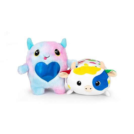 Meet the Daisy and Cow Monstah Pair: an adorable pastel blue and pink plush with horns and a shiny blue heart, plus a round, colorful spotted cow. Both are machine washable and perfect for cuddling!.