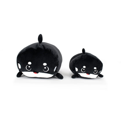 Fausto the Orca plushies—one large and one small—sit together on a white background, featuring black and white bodies, round shapes, smiling faces with rosy cheeks, and adorable star-shaped eyes.