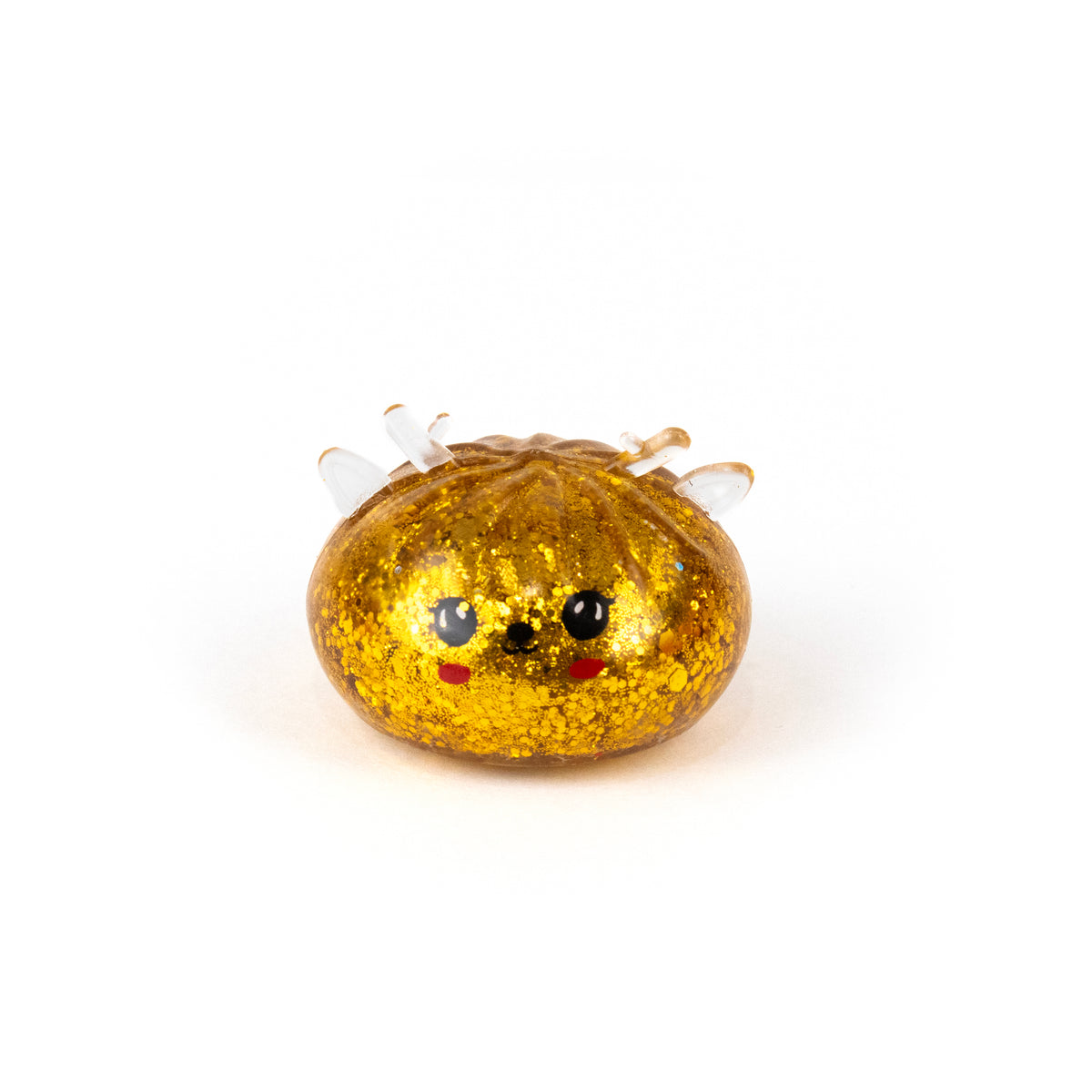 A small, golden, glitter-filled Bubblegum’s Favorite Toy - Jr Reindeer Mystery Maltose Dumpling shaped like a dumpling with a cute face and small white antlers.