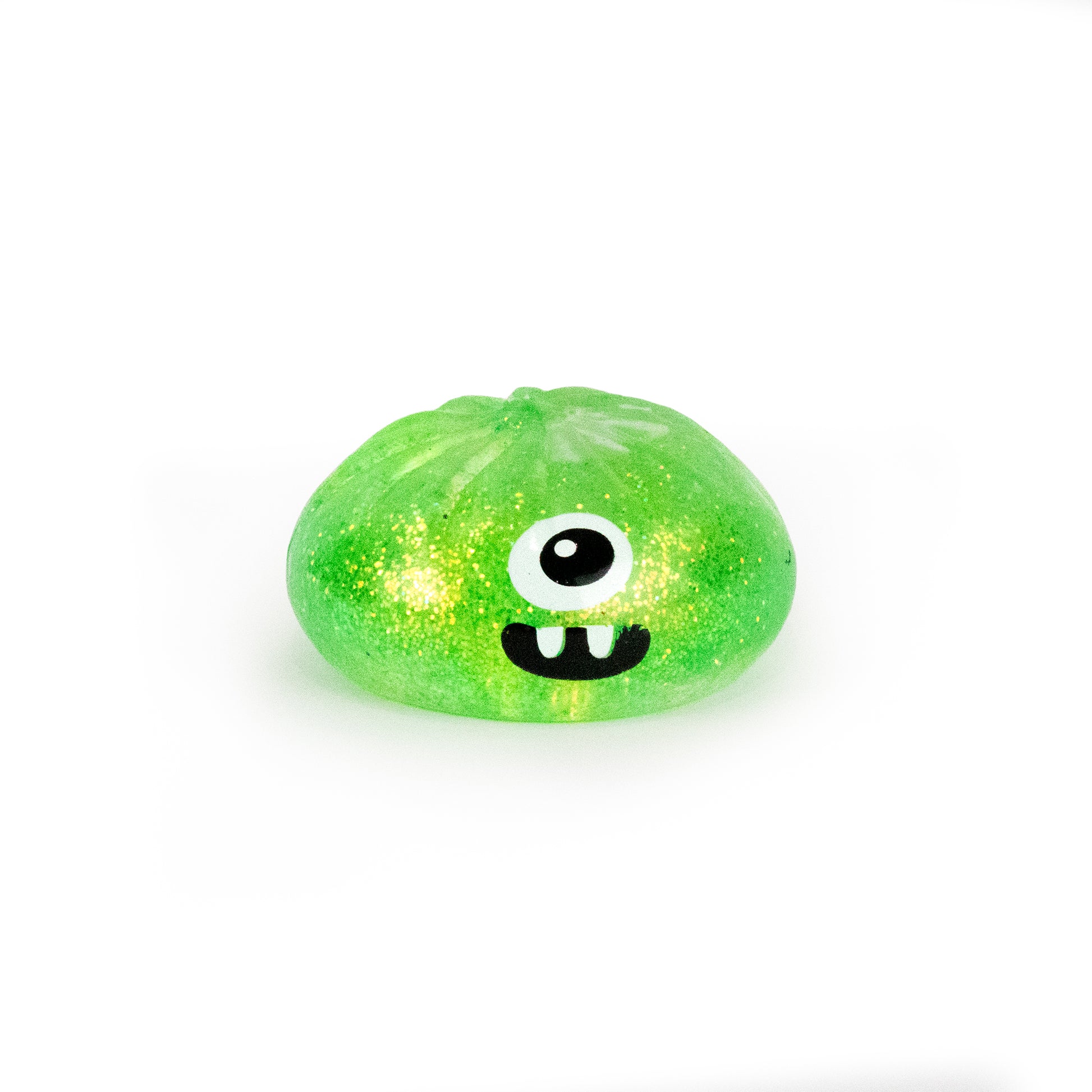 Bubblegum’s Favorite Toy - Spooky Mystery Dumpling, a small green blob with glitter, one large eye, and two teeth resembling a cute cartoon monster, sits on a white background.