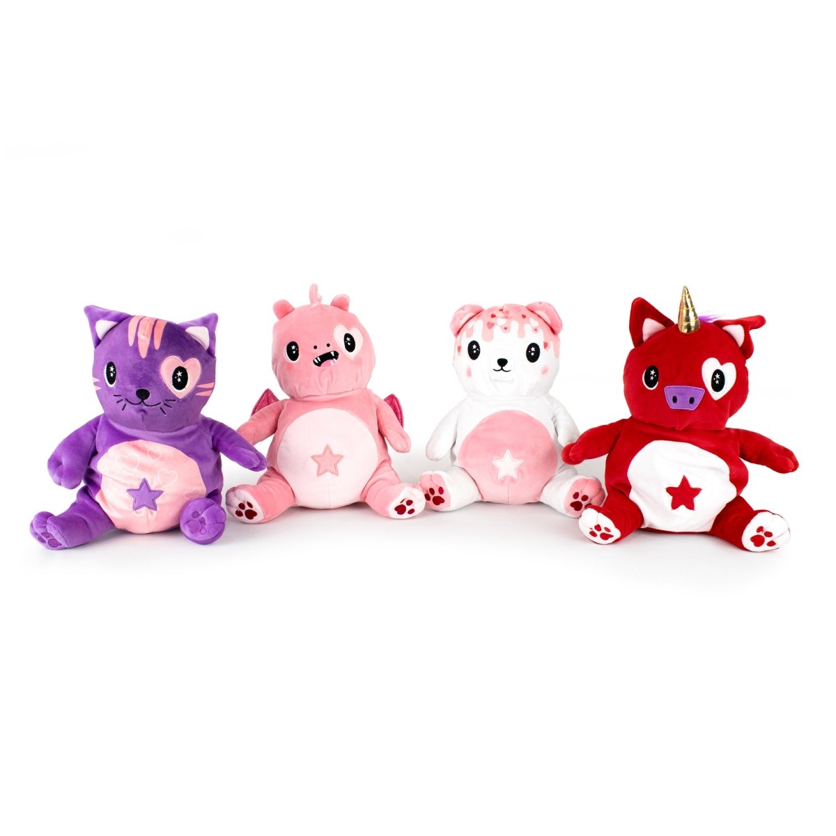 Four adorable plush toys are lined up: a purple cat with a star on its belly, Alma the Unicorn Starlight Buddy Plushie, a pink and white bear, and a red unicorn with a star on its belly. Each stuffed animal features a cute, smiling face.