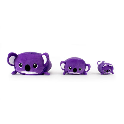 Three purple plush koalas from Moosh-Moosh Series 5 are arranged in a row on a white background. They have large eyes, round black noses, and short limbs. The leftmost is largest, while the smallest is Taz the Koala Plush Clip-On, making it adorable and portable.