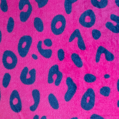The 2-in-1 Pillow Blanket - Spotty the Leopard features bright pink fabric with a soft, fuzzy texture and irregular dark blue leopard print spots scattered across the surface.
