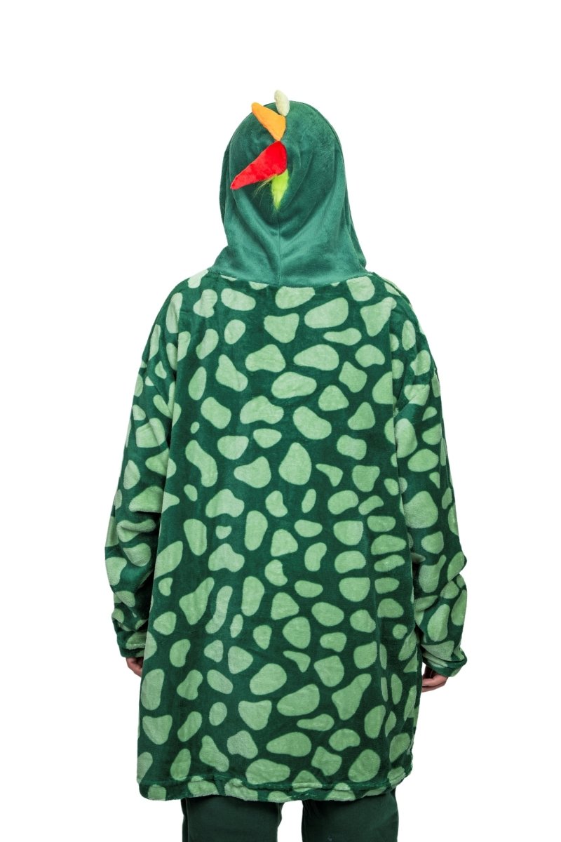 Wearing the Dinosaur Hooded Blanket, a person is seen from behind in a plush green costume featuring a scale pattern, colorful snout, and small spikes on the hood against a white backdrop.