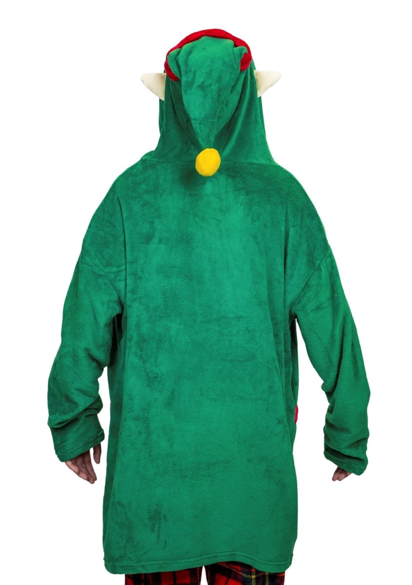 A person in a Jingle the Elf Hooded Blanket stands facing away, showcasing its soft, green fabric adorned with cute red and yellow accents. The whimsical outfit features a long hood with a yellow pom-pom and pointy ears like a plushie, paired with red plaid pants.