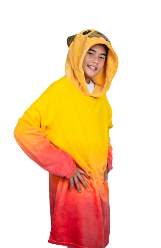 A smiling child wears a cozy, oversized Pug Hooded Blanket for kids with a hood designed like a pug's face. The soft tan and brown hoodie is perfect for snuggling, set against a plain white background.